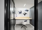 Thumbnail 22 of 36 - A Room with a White Desk and Chair at Peregrine Apartments, Minneapolis, MN, 55411