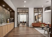 Thumbnail 16 of 55 - A modern kitchen with wooden floors and a dining area with a table and chairs.