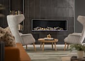 Thumbnail 20 of 55 - A modern living room with a fireplace and two chairs.