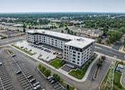 Thumbnail 64 of 70 - A large building with a parking lot in front of it.