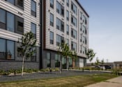Thumbnail 59 of 70 - A modern building with a striped facade and trees in front.