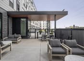 Thumbnail 57 of 70 - A patio with a table and chairs is in front of a building.