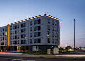 Thumbnail 70 of 70 - A modern multi-story building with a flat roof and a mix of windows and balconies.