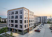 Thumbnail 67 of 70 - A modern building with a parking lot in front.