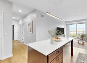 Thumbnail 32 of 55 - A modern kitchen with a large island and wooden cabinets.at The Rosalyn | Affordable 55+ Apartments in Bloomington, Bloominton Minnesota
