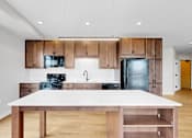 Thumbnail 43 of 55 - A modern kitchen with a large island in the middle.