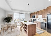 Thumbnail 26 of 55 - A modern kitchen with wooden cabinets and a large island.at The Rosalyn | Affordable 55+ Apartments in Bloomington, Minnesota, 55420