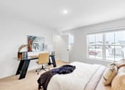 Thumbnail 34 of 113 - A white bedroom with a large bed and a desk with a chair.