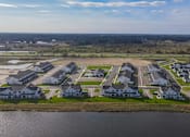 Thumbnail 103 of 113 - A bird's eye view of a residential area with houses and a body of water.