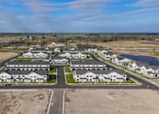 Thumbnail 102 of 113 - A bird's eye view of a residential area with houses and a lake.