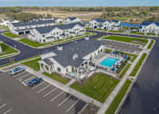 Thumbnail 97 of 113 - A large white building with a pool in the middle of a parking lot.