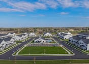 Thumbnail 106 of 113 - A suburban neighborhood with houses and a central green space.
