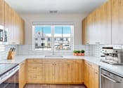 Thumbnail 13 of 49 - A kitchen with wooden cabinets and stainless steel appliances.