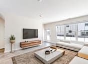 Thumbnail 16 of 49 - A modern living room with a flat screen TV and a white sofa.