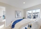 Thumbnail 6 of 49 - A bedroom with a large bed and a window overlooking a building.