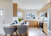 Thumbnail 2 of 49 - A modern kitchen with a dining table and chairs.