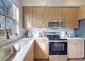 Thumbnail 3 of 49 - A kitchen with wooden cabinets and stainless steel appliances.