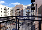 Thumbnail 101 of 104 - A view from a balcony overlooking a street with cars and buildings.