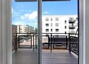 Thumbnail 100 of 104 - A balcony with a railing and a view of a building across the way.