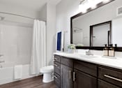 Thumbnail 104 of 104 - A bathroom with a white tub, sink, and toilet.