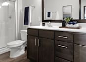 Thumbnail 102 of 104 - A bathroom with a white toilet and a wooden cabinet.