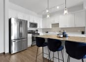 Thumbnail 61 of 104 - a kitchen with stainless steel appliances and an island with blue chairs