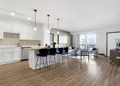 Thumbnail 54 of 104 - an open kitchen and living room with an island and bar stools