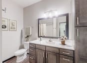 Thumbnail 53 of 104 - A bathroom with a toilet, sink, and mirror.