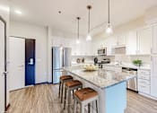 Thumbnail 51 of 104 - A kitchen with a blue island and white cabinets.