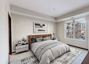 Thumbnail 60 of 104 - A bedroom with a large bed and a window overlooking a cityscape.