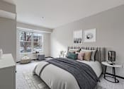 Thumbnail 50 of 104 - A bedroom with a large bed and a window overlooking a tree.