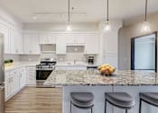 Thumbnail 47 of 104 - A kitchen with a granite countertop and stainless steel appliances.