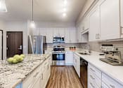 Thumbnail 35 of 104 - A kitchen with granite countertops and stainless steel appliances.