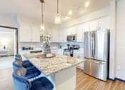 Thumbnail 27 of 104 - A kitchen with a marble countertop and stainless steel appliances.
