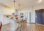 Thumbnail 44 of 104 - A kitchen with a white island and stools.
