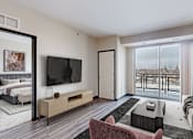 Thumbnail 46 of 104 - A modern living room with a large window overlooking a balcony.
