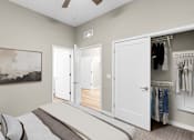 Thumbnail 56 of 123 - A bedroom with a large bed and a wardrobe with clothes hanging in it.