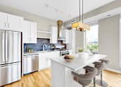 Thumbnail 49 of 123 - A modern kitchen with a white island and stainless steel appliances.