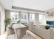 Thumbnail 51 of 123 - A modern living room with a fireplace and a dining table set up.