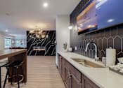 Thumbnail 18 of 91 - a kitchen with a long counter and stools in front of it at The Morrison, Rosemount Minnesota