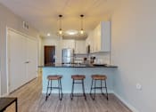 Thumbnail 44 of 91 - a kitchen with a large island with three stools in front of it at The Morrison, Rosemount Minnesota