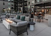 Thumbnail 60 of 64 - A patio with a fire pit and chairs.