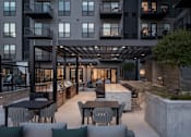 Thumbnail 62 of 64 - A modern outdoor patio area with a table and chairs.
