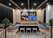 Thumbnail 16 of 64 - A modern living room with a large TV screen and comfortable seating.