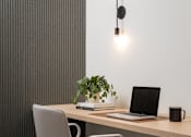 Thumbnail 11 of 64 - A modern office chair is placed in front of a wooden desk with a laptop, a plant, and a black mug on it.