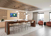Thumbnail 7 of 64 - A modern office space with a long wooden table and chairs, a television on the wall, and a view of the city outside the windows.