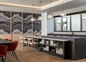 Thumbnail 15 of 64 - A modern kitchen with a black countertop and red chairs.