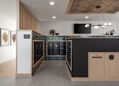 Thumbnail 19 of 64 - A modern kitchen with a black countertop and wooden cabinets.