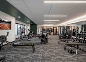 Thumbnail 20 of 64 - A gym with a variety of equipment including treadmills, weights, and exercise machines.