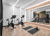 Thumbnail 21 of 64 - A gym with exercise bikes and a large mirror.